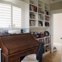 rolltop desk in a white room with bookshelves
